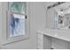 Bathroom vanity with white drawers, mirror, and a window at 2204 Monterey Ave, Las Vegas, NV 89104