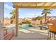 Inviting backyard oasis featuring a sparkling pool, covered patio, and lush landscaping at 262 Cielito Lindo St, Henderson, NV 89012