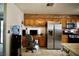 Bright kitchen featuring oak cabinets, stainless steel appliances, and a built-in desk area for added convenience at 2905 Gentilly Ln, Las Vegas, NV 89108