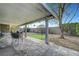 Relaxing covered patio with stone flooring and a cozy seating area in the landscaped backyard at 291 Lido Dr, Henderson, NV 89015