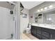Bathroom featuring a shower with gray cabinets, double sinks and tile floor at 291 Lido Dr, Henderson, NV 89015