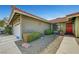 Home exterior featuring a desert landscape, shrubs, and an attached two-car garage with a concrete driveway at 291 Lido Dr, Henderson, NV 89015
