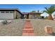 View of the front of the home, showcasing a red tile roof, a brick walkway, and desert landscaping at 291 Lido Dr, Henderson, NV 89015