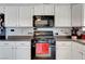 Close-up shot of a kitchen featuring black appliances, white cabinets, and a tiled backsplash at 291 Lido Dr, Henderson, NV 89015