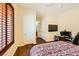 This bedroom has wood floors, plantation shutters, and a TV at 4 Dry Brook Trl, Henderson, NV 89052