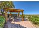 Picturesque gazebo with comfortable seating and views of the landscaped backyard and distant mountains at 4 Dry Brook Trl, Henderson, NV 89052