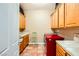 Laundry room showcasing ample cabinetry, a red washer, and tile flooring at 4 Dry Brook Trl, Henderson, NV 89052