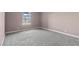 A carpeted bedroom with neutral walls features a single window that provides natural light at 4050 Pacific Harbors Dr # 229, Las Vegas, NV 89121
