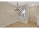 Cozy dining area with a modern chandelier, large window, and light wood floors at 4400 S Jones Blvd # 2103, Las Vegas, NV 89103