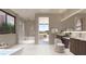 Modern bathroom featuring a soaking tub, walk-in shower, dual vanity and light tile flooring at 6 Harlow View Ct # 18, Henderson, NV 89012