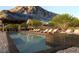 Inviting pool area with lounge chairs, covered seating, and scenic mountain views at 6 Harlow View Ct # 18, Henderson, NV 89012