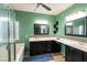 Bright green bathroom with a tiled vanity, dual sinks, shower, and bathtub creating a refreshing ambiance at 6636 Brent Scott St, North Las Vegas, NV 89086