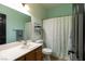 Bathroom with mint green walls, large mirror, and shower with curtain at 6636 Brent Scott St, North Las Vegas, NV 89086