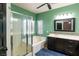 Bathroom with a bathtub, shower, sink with dark wood cabinets, and green walls at 6636 Brent Scott St, North Las Vegas, NV 89086