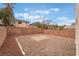 A large backyard with stone and dirt, enclosed by a tall block wall at 7013 Pacific Coast St, Las Vegas, NV 89148