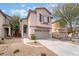 Two-story home with attached two car garage and low maintenance desert landscaping in front at 7013 Pacific Coast St, Las Vegas, NV 89148