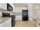 Practical kitchen features white cabinets, black appliances, and durable tile flooring at 7013 Pacific Coast St, Las Vegas, NV 89148