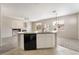 Bright kitchen features an island with sink, with tiled floors and view to living room with fireplace at 7013 Pacific Coast St, Las Vegas, NV 89148