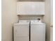 Convenient laundry room equipped with a washer, dryer, and overhead cabinets at 7013 Pacific Coast St, Las Vegas, NV 89148