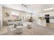 Sunlit living room featuring modern furniture, plush carpet, and an open layout connecting to the kitchen and dining areas at 7013 Pacific Coast St, Las Vegas, NV 89148