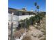 Overgrown backyard featuring the exterior of the building and chain link fence at 717 Madison Ave, Las Vegas, NV 89106