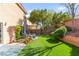 This backyard features artificial turf, mature trees, patio area with outdoor furniture at 7505 Mission Palm St, Las Vegas, NV 89139