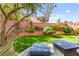 Beautiful backyard featuring artificial grass, mature landscaping, and patio furniture for relaxation at 7505 Mission Palm St, Las Vegas, NV 89139