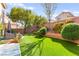 Beautiful backyard features artificial turf, manicured garden beds, fountain, and outdoor seating at 7505 Mission Palm St, Las Vegas, NV 89139