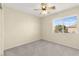 This bedroom features a neutral color scheme, ceiling fan, and a large window at 7505 Mission Palm St, Las Vegas, NV 89139