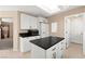 Modern kitchen with an island, white cabinets, and sleek black countertops at 7505 Mission Palm St, Las Vegas, NV 89139