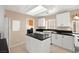 Well-lit kitchen featuring an island with black countertops and white cabinetry at 7505 Mission Palm St, Las Vegas, NV 89139