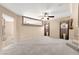 Spacious living room with neutral walls, plush carpet, large cut out, and a view of the staircase at 7505 Mission Palm St, Las Vegas, NV 89139