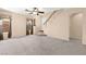 Living room with carpet flooring, neutral walls, a ceiling fan and staircase at 7505 Mission Palm St, Las Vegas, NV 89139