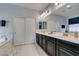 Bathroom with double sinks, dark cabinets, and a separate tub and shower at 7553 Old Compton St, Las Vegas, NV 89166