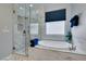 Modern bathroom featuring a glass-enclosed shower, soaking tub, and elegant tile work at 7553 Old Compton St, Las Vegas, NV 89166