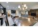 Stylish kitchen with black cabinets, stainless steel appliances, and an island with bar seating, open to the living area at 7553 Old Compton St, Las Vegas, NV 89166