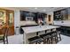 A modern kitchen with stainless steel appliances, granite countertops, and a large central island with seating at 7553 Old Compton St, Las Vegas, NV 89166