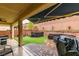 Covered patio featuring a tiled floor, brick walls, and outdoor seating area, perfect for relaxation at 7553 Old Compton St, Las Vegas, NV 89166