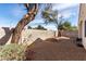 Expansive gravel backyard featuring mature trees and a block wall, offering privacy and natural beauty at 7628 Picnic St, Las Vegas, NV 89131
