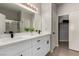 Bathroom featuring double sinks with white cabinets, modern lighting, and a large mirror at 7628 Picnic St, Las Vegas, NV 89131