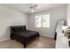Serene bedroom with light wood floors, ceiling fan, and a large window for natural light at 7628 Picnic St, Las Vegas, NV 89131