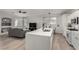 Bright, open-concept living room with modern kitchen island, stainless appliances, and a cozy gray sofa at 7628 Picnic St, Las Vegas, NV 89131