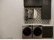 The laundry room features dark wood cabinets, designer backsplash and stainless steel washer and dryer at 8 Rue Du Ville Way, Henderson, NV 89011