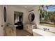 Luxurious primary bathroom with marble countertops, soaking tub, and large windows offering picturesque views at 8 Rue Du Ville Way, Henderson, NV 89011
