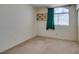 Standard bedroom with a medium window and neutral walls and carpet at 8012 Pottery Creek Dr, Las Vegas, NV 89128