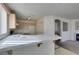 The kitchen has tiled countertops, overhead lighting and view to the living room at 8012 Pottery Creek Dr, Las Vegas, NV 89128