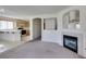 Cozy living space featuring a fireplace, open kitchen access, and a carpeted floor at 8012 Pottery Creek Dr, Las Vegas, NV 89128