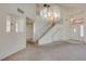 Light-filled living room featuring a grand staircase, chandelier and a welcoming front entrance at 8012 Pottery Creek Dr, Las Vegas, NV 89128
