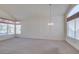 Bright living room with a vaulted ceiling, large windows, and a decorative chandelier at 8012 Pottery Creek Dr, Las Vegas, NV 89128