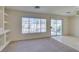 Bright living room with built-in shelving, window, and sliding glass door to backyard at 8012 Pottery Creek Dr, Las Vegas, NV 89128